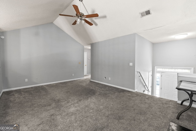 interior space with carpet flooring, vaulted ceiling, baseboards, visible vents, and a ceiling fan