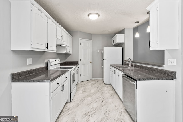 kitchen featuring under cabinet range hood, dark countertops, a sink, and white appliances