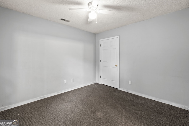 unfurnished room featuring dark colored carpet, a textured ceiling, ceiling fan, and visible vents