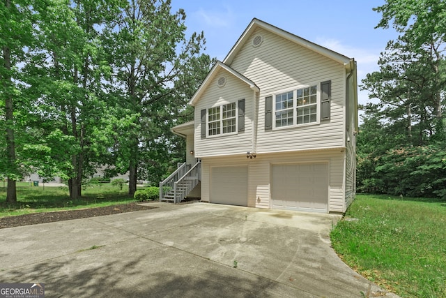 view of side of home with a garage, stairs, and concrete driveway