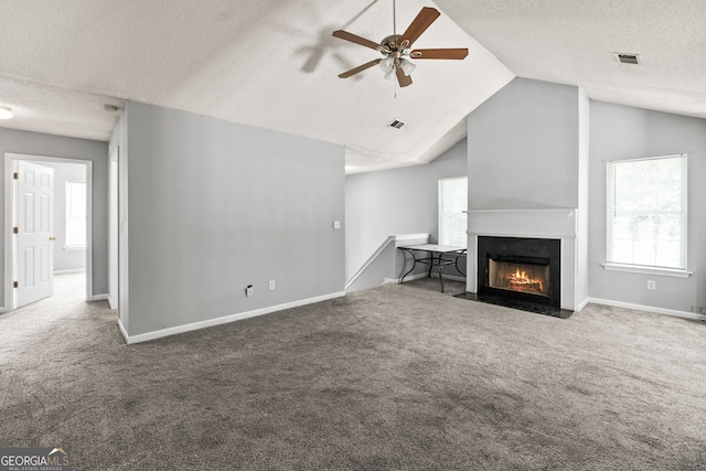 unfurnished living room with lofted ceiling, carpet, visible vents, and a ceiling fan