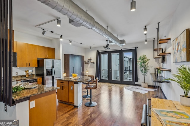 5300 Peachtree Rd Unit 3601, Atlanta, GA 30341 - kitchen with stainless steel appliances, a kitchen bar, brown cabinetry, and hardwood / wood-style floors