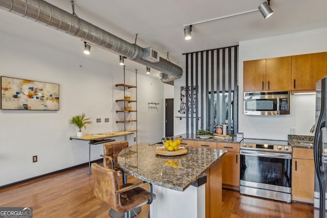 5300 Peachtree Rd Unit 3601, Atlanta, GA 30341 - kitchen featuring appliances with stainless steel finishes, rail lighting, brown cabinets, and dark wood-style floors
