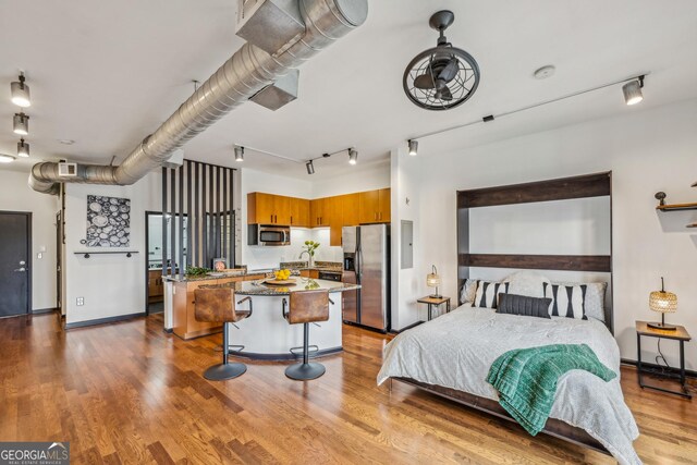 5300 Peachtree Rd Unit 3601, Atlanta, GA 30341 - bedroom featuring stainless steel fridge, wood finished floors, track lighting, baseboards, and a sink