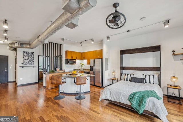 5300 Peachtree Rd Unit 3601, Atlanta, GA 30341 - bedroom featuring stainless steel refrigerator with ice dispenser, wood finished floors, rail lighting, baseboards, and a sink