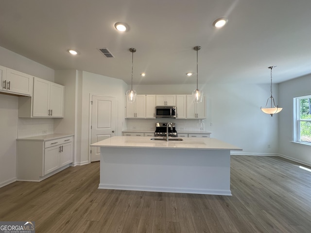 kitchen featuring white cabinets, stainless steel appliances, tasteful backsplash, and a sink