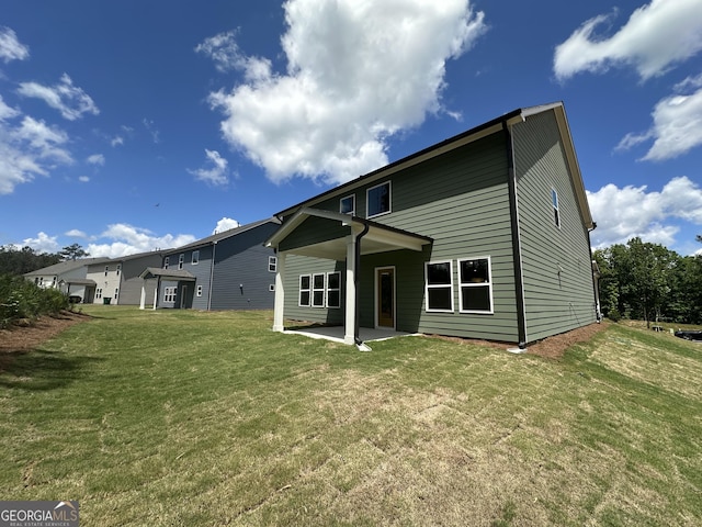 back of property featuring a yard and a patio