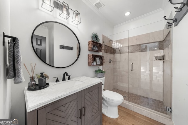 full bath with toilet, wood finished floors, a shower stall, crown molding, and vanity