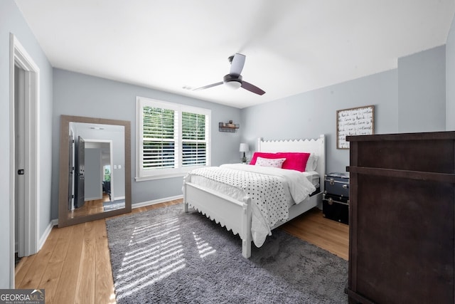 bedroom with wood finished floors, baseboards, and ceiling fan