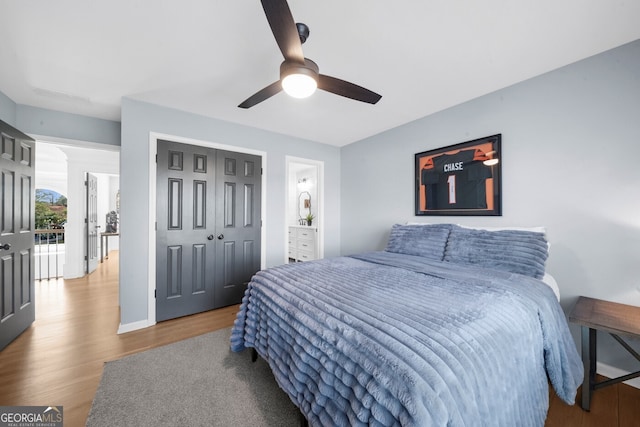 bedroom with ceiling fan, wood finished floors, and a closet
