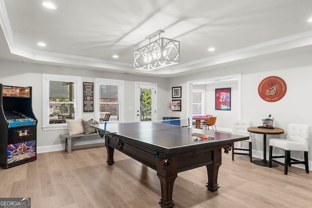 recreation room with baseboards, light wood-style flooring, ornamental molding, and a raised ceiling