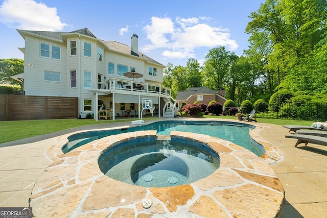 view of pool featuring fence, stairs, a pool with connected hot tub, and a patio