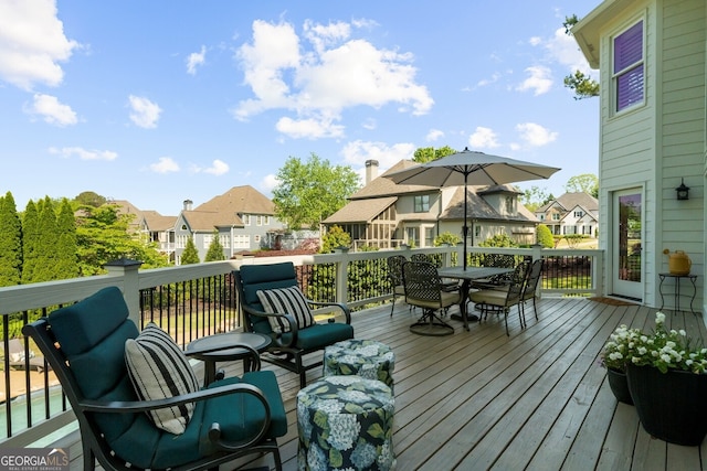 wooden terrace with outdoor dining area and a residential view