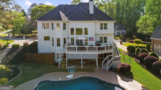 rear view of house featuring a fenced backyard, stairway, a chimney, and a patio