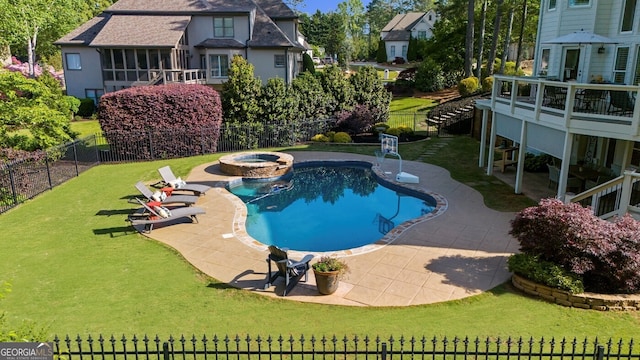 view of swimming pool featuring a yard, a pool with connected hot tub, a patio, and a fenced backyard