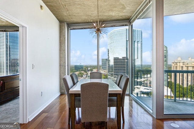 dining area with floor to ceiling windows, wood finished floors, a wealth of natural light, and a notable chandelier