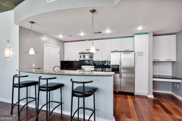 kitchen with a breakfast bar area, stainless steel appliances, dark wood finished floors, white cabinetry, and visible vents