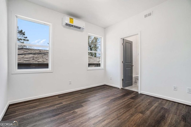 102 Dahlia Ave SW, Atlanta, GA 30314 - spare room featuring dark wood-style floors, visible vents, baseboards, and an AC wall unit
