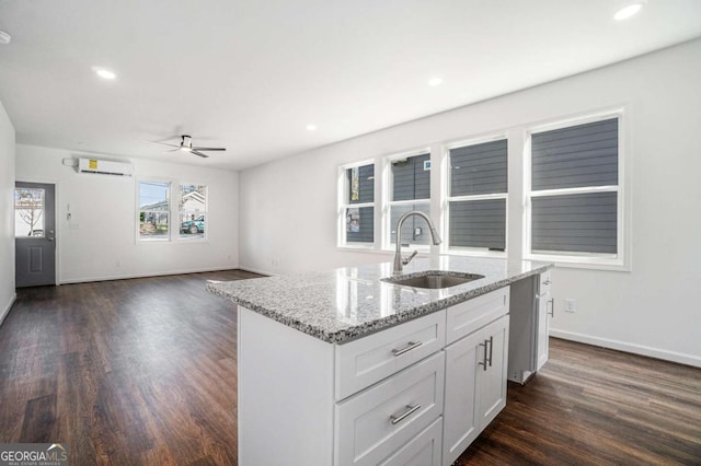 102 Dahlia Ave SW, Atlanta, GA 30314 - kitchen featuring a sink, a wall unit AC, dark wood-style flooring, a ceiling fan, and light stone countertops