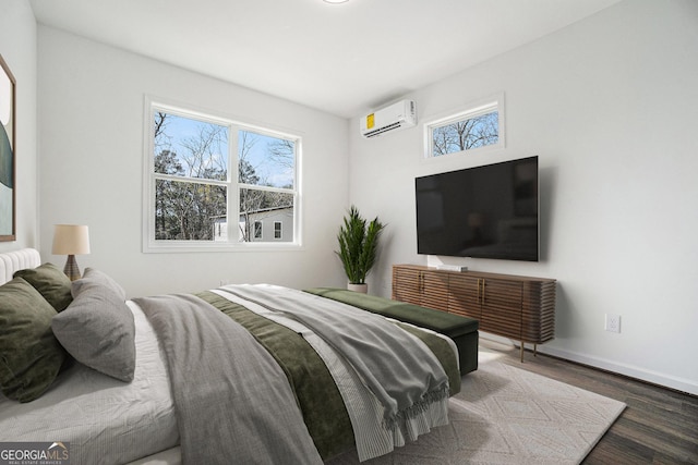 102 Dahlia Ave SW, Atlanta, GA 30314 - bedroom with wood finished floors, baseboards, an AC wall unit, and multiple windows