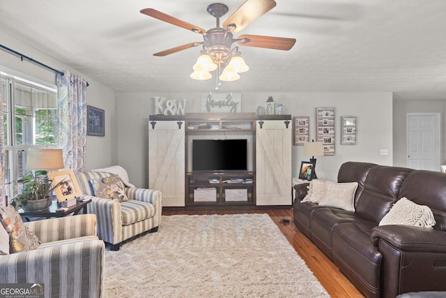 living room with a ceiling fan and wood finished floors