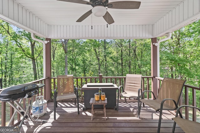 wooden terrace with area for grilling and ceiling fan