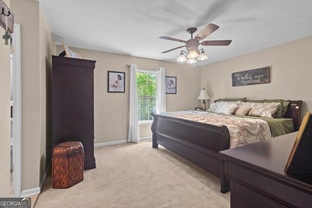 bedroom with light colored carpet, baseboards, and a ceiling fan