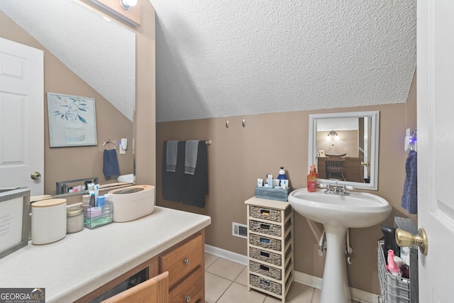 bathroom featuring vaulted ceiling, a textured ceiling, tile patterned flooring, and visible vents