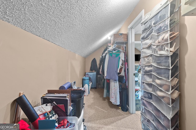 walk in closet with vaulted ceiling and carpet flooring