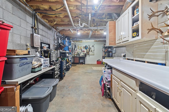 unfinished basement with a workshop area and concrete block wall