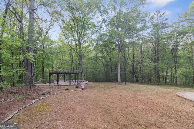 view of yard with a gazebo and a view of trees