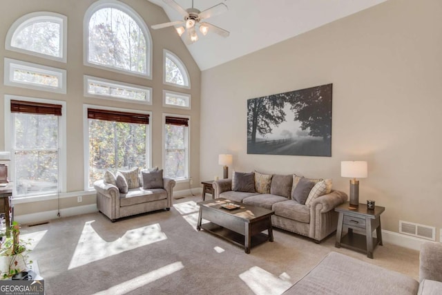 carpeted living room featuring high vaulted ceiling, baseboards, a ceiling fan, and visible vents