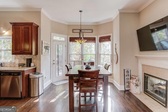 dining space featuring dark wood finished floors, baseboards, and ornamental molding