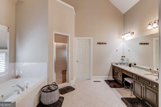 full bath featuring high vaulted ceiling, a garden tub, tile patterned floors, a stall shower, and double vanity