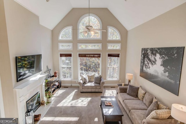 living area featuring high vaulted ceiling, a ceiling fan, and carpet