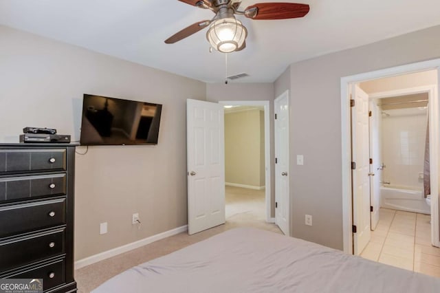 bedroom featuring ensuite bath, baseboards, a ceiling fan, and visible vents