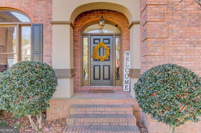 entrance to property with brick siding and stucco siding
