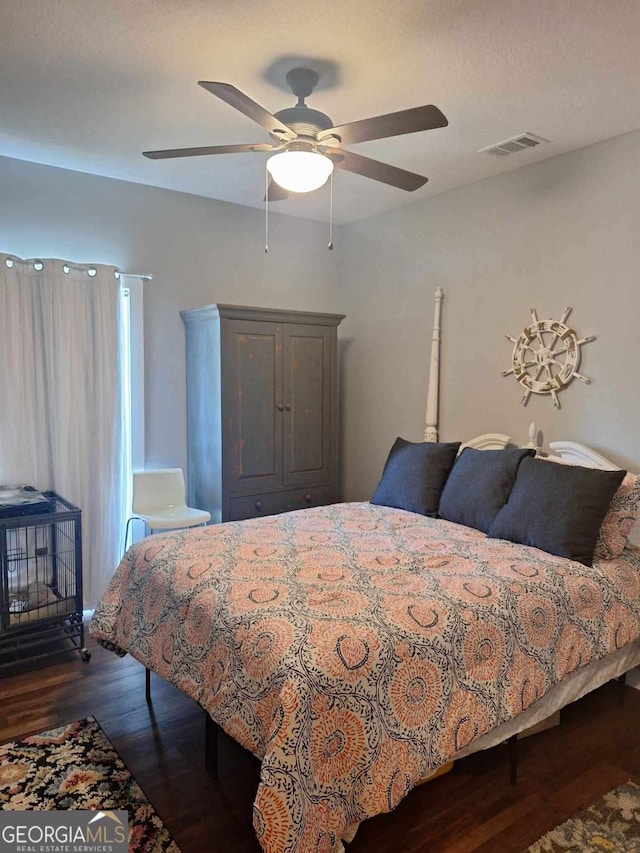 471 Getaway Ln, Baxley, GA 31513 - bedroom featuring a wood stove, dark wood-type flooring, and ceiling fan