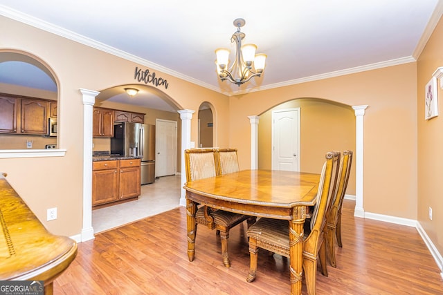 dining area with a chandelier, crown molding, and light wood-style flooring