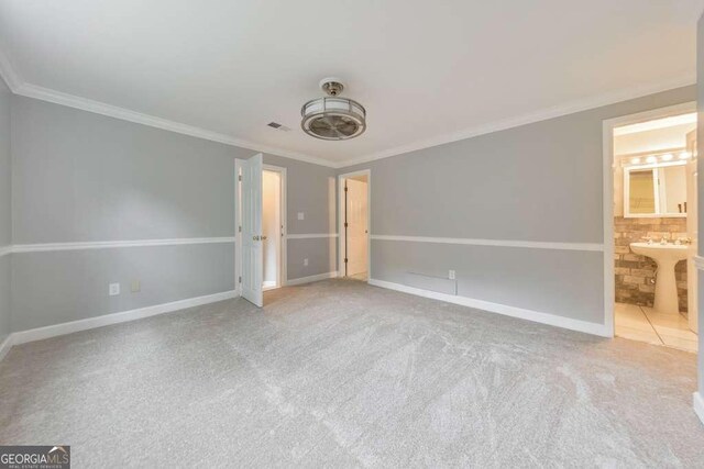 unfurnished bedroom with ornamental molding, baseboards, carpet flooring, and ensuite bathroom