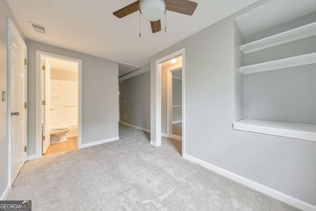 unfurnished bedroom featuring carpet, ensuite bath, baseboards, and ceiling fan
