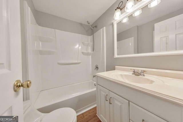 bathroom with vanity, toilet, wood finished floors, and bathing tub / shower combination