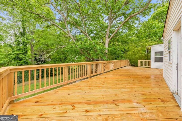 wooden terrace with view of wooded area