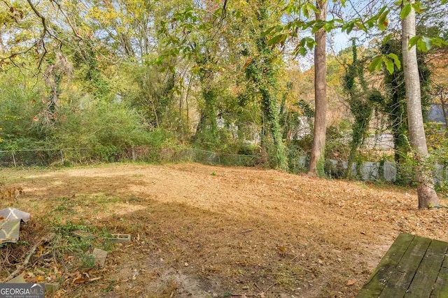 view of yard with fence and a view of trees