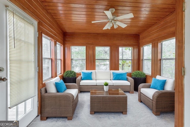 sunroom with healthy amount of natural light, wood ceiling, vaulted ceiling, wooden walls, and carpet floors