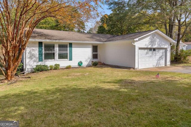 ranch-style house featuring a garage, concrete driveway, and a front yard