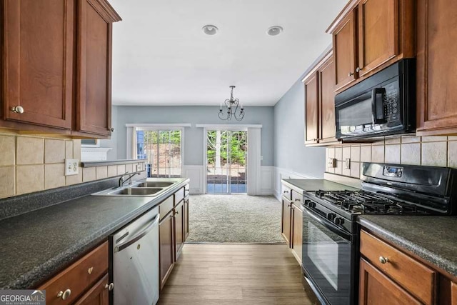 2872 Cross Creek Ct, Cumming, GA 30040 - kitchen with a wainscoted wall, dark countertops, wood finished floors, a sink, and black appliances