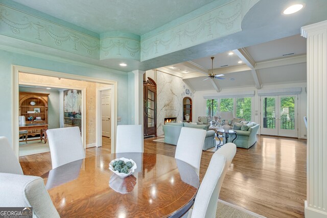 2436 Hawthorne Ln, Gainesville, GA 30506 - dining space featuring wood finished floors, a premium fireplace, crown molding, ceiling fan, and beamed ceiling