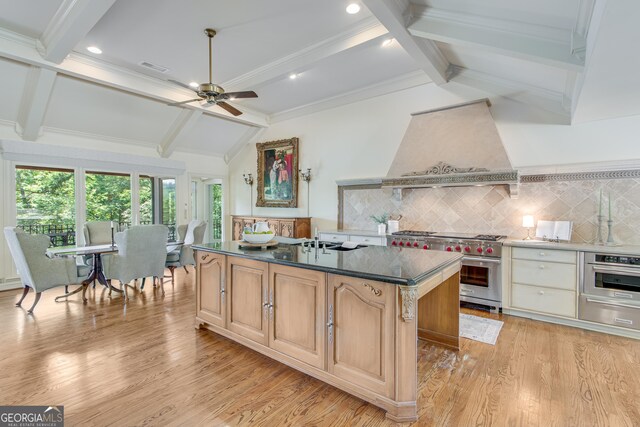 2436 Hawthorne Ln, Gainesville, GA 30506 - kitchen with range with two ovens, custom range hood, a kitchen island, a ceiling fan, and decorative backsplash