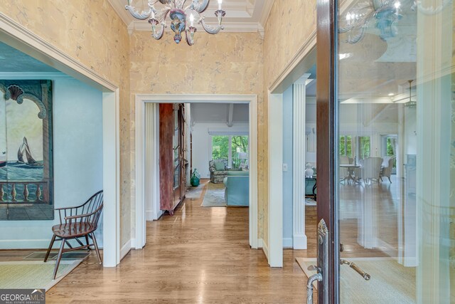 2436 Hawthorne Ln, Gainesville, GA 30506 - hallway featuring ornamental molding, a chandelier, a towering ceiling, and wood finished floors
